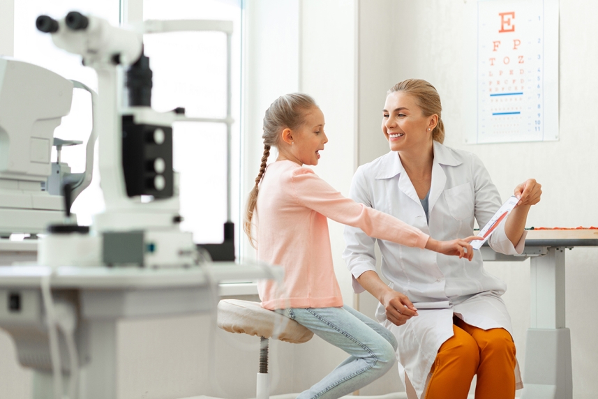 A young girl talks with her eye care provider about color blindness
