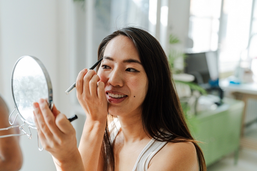 A woman applying makeup while wearing contact lenses 