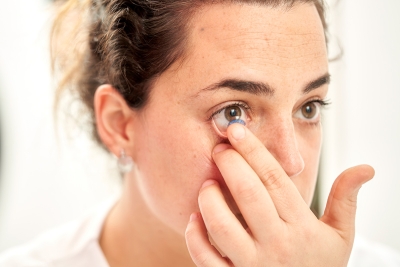 A woman putting a contact in her eye