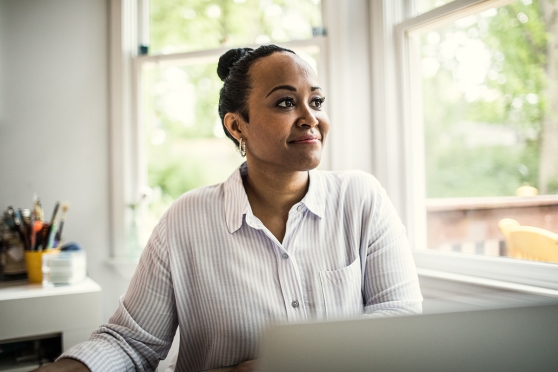 Woman working at laptop, smiling
