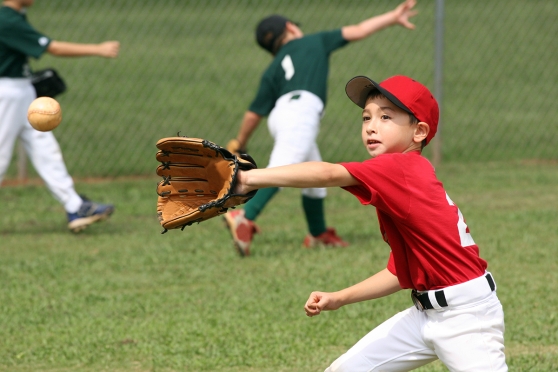 A young boy playing baseball, a sport that may put his eyes at risk