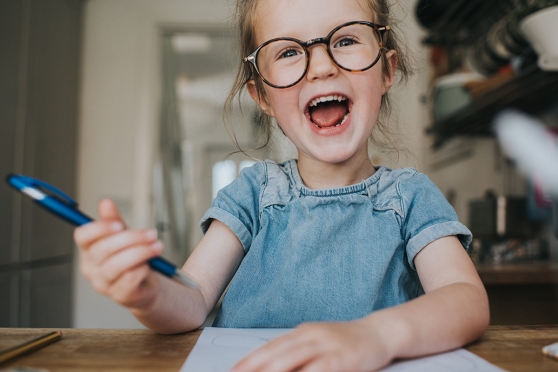 Kid with glasses drawing pictures