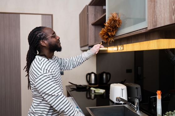 A man dusting to keep allergies from affecting his eyes