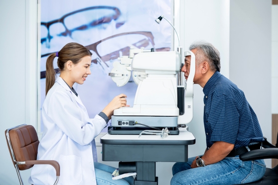 Eye doctor examining an older man’s eyes for signs of diabetic retinopathy 
