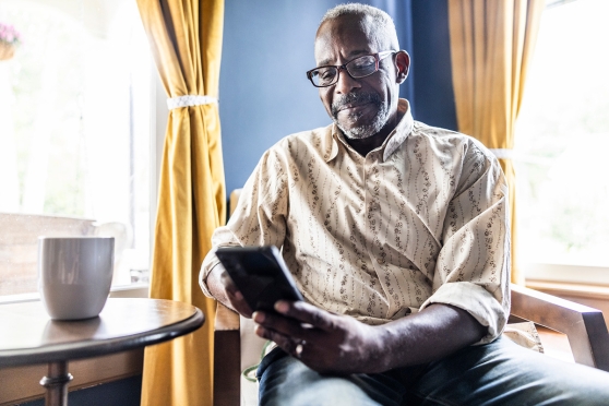 An older adult man reviewing information about how Alzheimer’s may affect his eyes