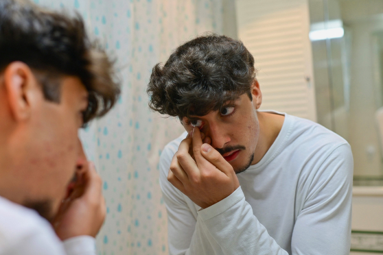 Man putting on contact lenses 