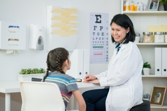 A child talks with their doctor about pink eye