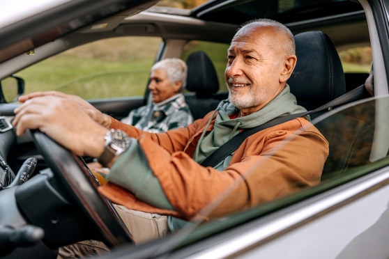 Older man safely driving with his spouse 