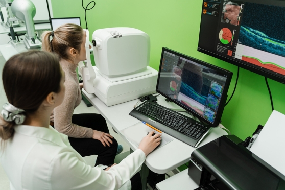 An eye doctor using technology to detect and treat AMD in a patient 