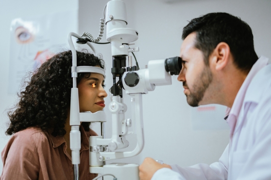 An eye doctor doing an eye exam on an adult woman 