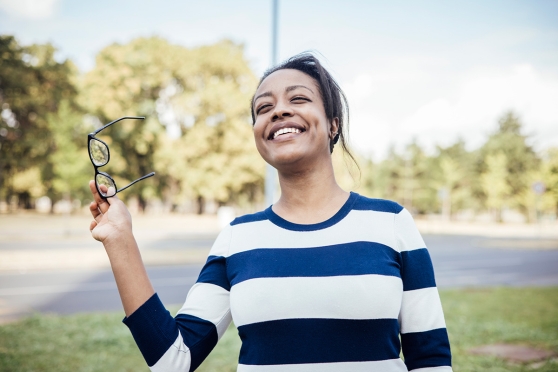 Woman holding glasses outside