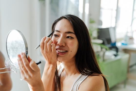 A woman applying makeup while wearing contact lenses 