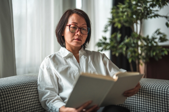 Woman reading book on couch
