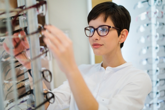Adult woman choosing glasses based on her hairstyle 