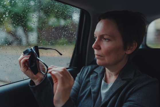 A person protecting their glasses from the rain 